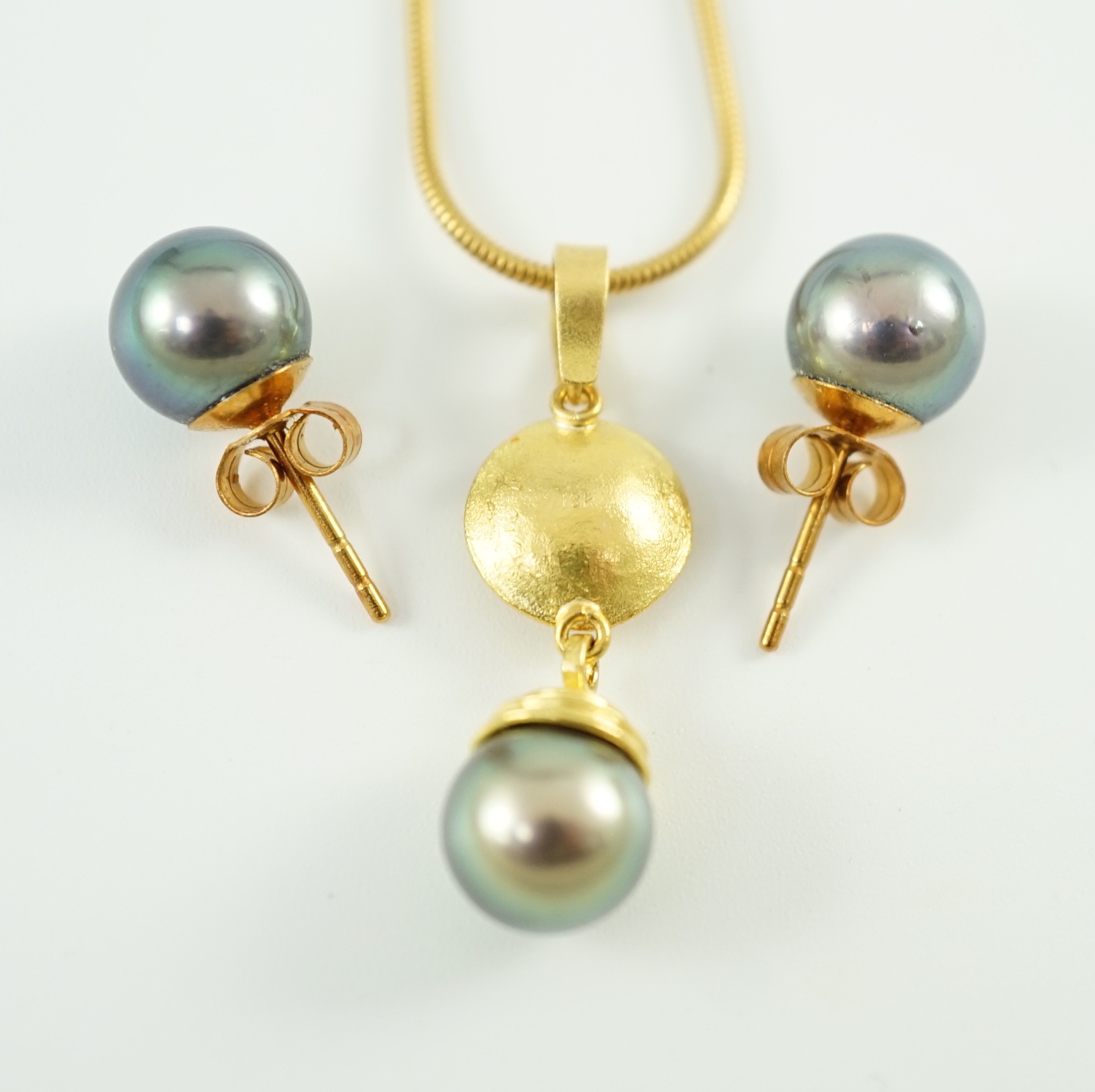 A modern textured gold, diamond and Tahitian pearl set drop pendant, on an 18ct gold snake link chain, in Asprey & Garrard box and a pair of 18ct gold and Tahitian pearl earrings, in Asprey & Garrard box